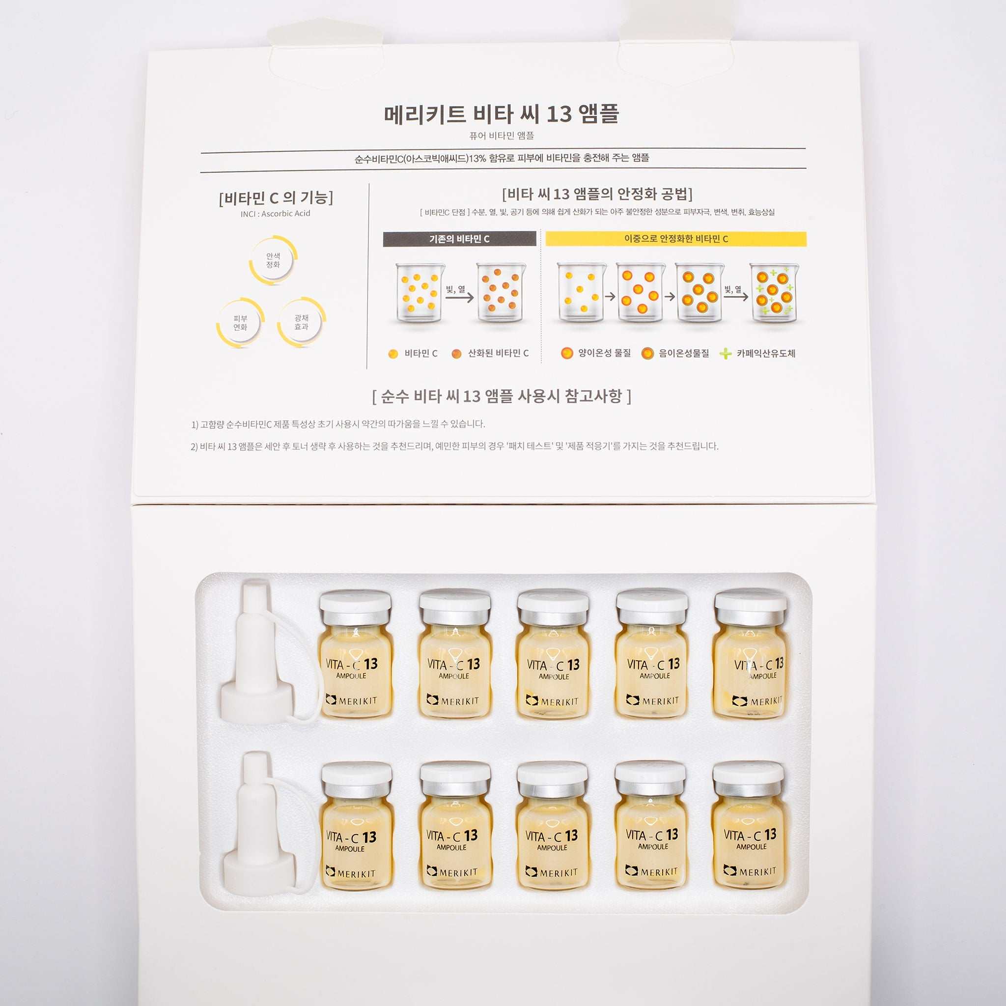 Box of MERIKIT Vita-C 13 Ampoules with ten small glass vials containing vitamin C serum and two applicator droppers on white background