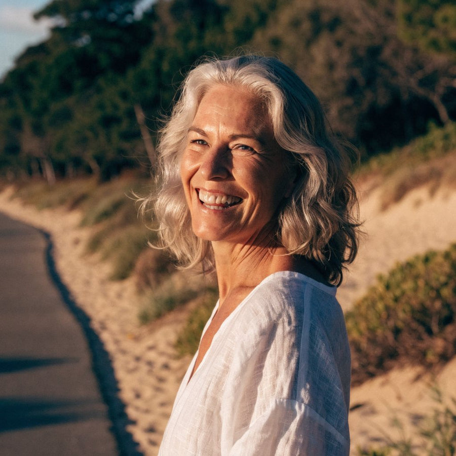 A silver haired woman smiling with radiant skin